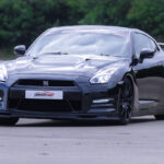 Nissan GTR on a racetrack, highlighting its sleek, aerodynamic design and powerful stance. This image showcases why the Nissan GTR is an excellent choice for a driving experience day, emphasizing its high performance and thrilling speed capabilities that appeal to car enthusiasts and thrill-seekers