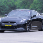 Nissan GTR on a racetrack, highlighting its sleek, aerodynamic design and powerful stance. This image showcases why the Nissan GTR is an excellent choice for a driving experience day, emphasizing its high performance and thrilling speed capabilities that appeal to car enthusiasts and thrill-seekers