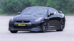 Nissan GTR on a racetrack, highlighting its sleek, aerodynamic design and powerful stance. This image showcases why the Nissan GTR is an excellent choice for a driving experience day, emphasizing its high performance and thrilling speed capabilities that appeal to car enthusiasts and thrill-seekers